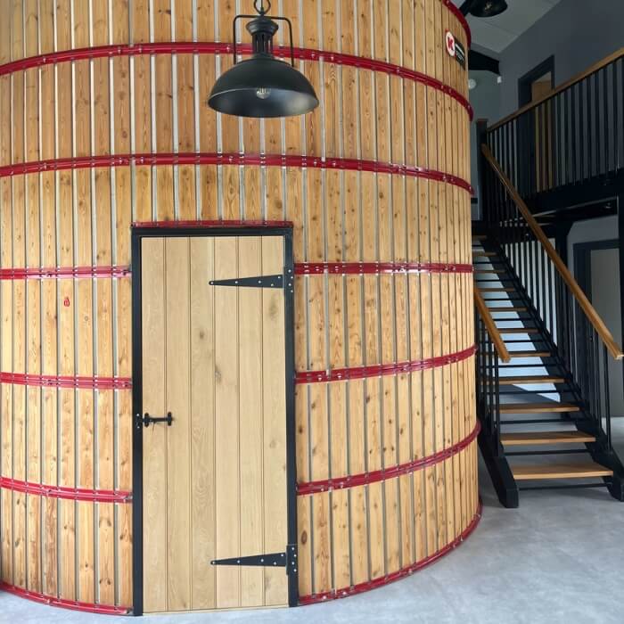 Sturdy oak internal door with black iron accents, part of a unique Silo in a converted grainstore