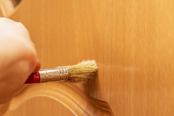 Cleaning oak door with paintbrush